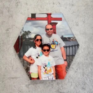 Zeshoekige foto op acryl met een gezinsfoto voor een rode torii-poort, tegen een grijze betonnen muur